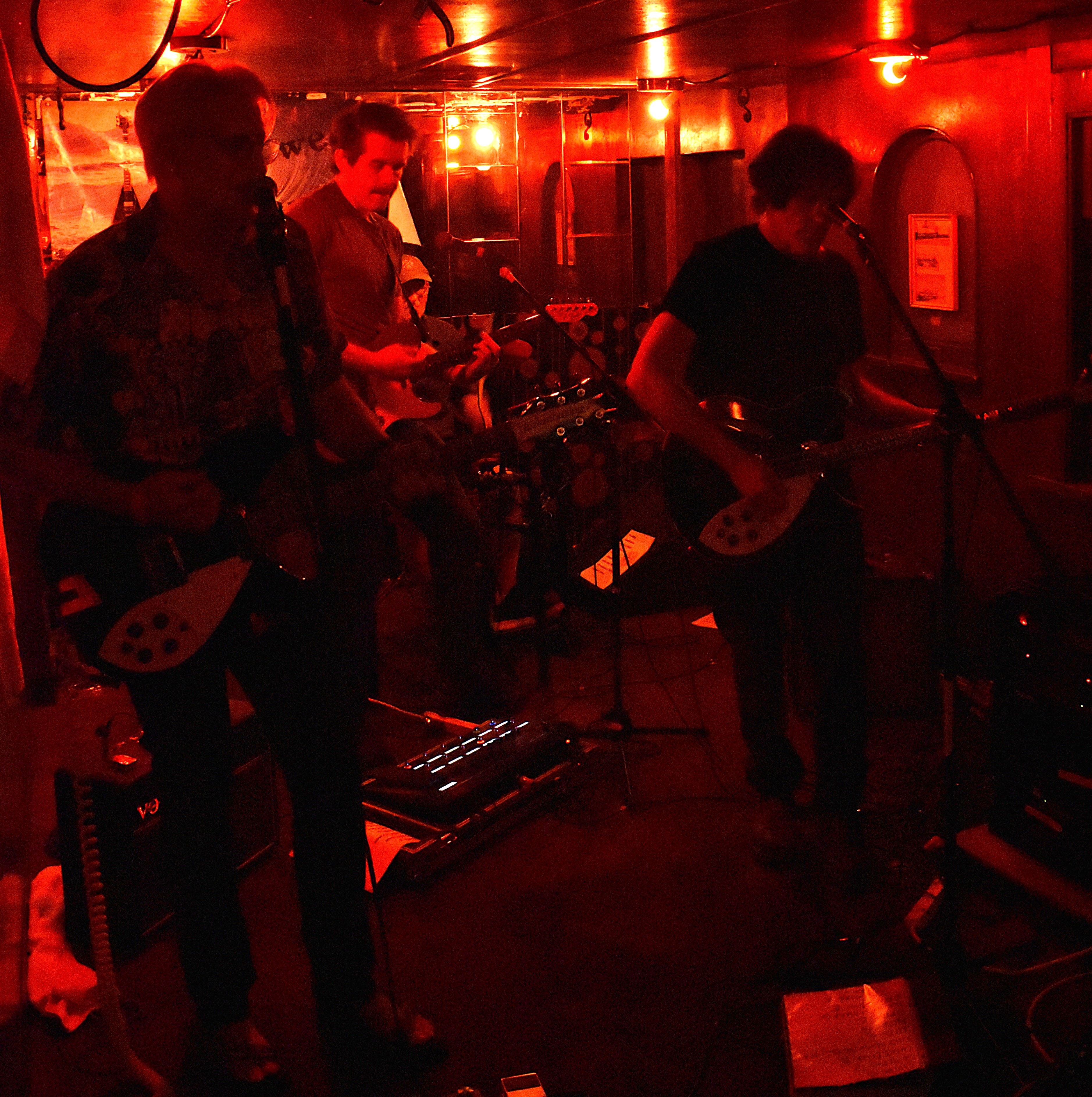 Abbey Cats performing under red lights at the Orient Express in Seattle